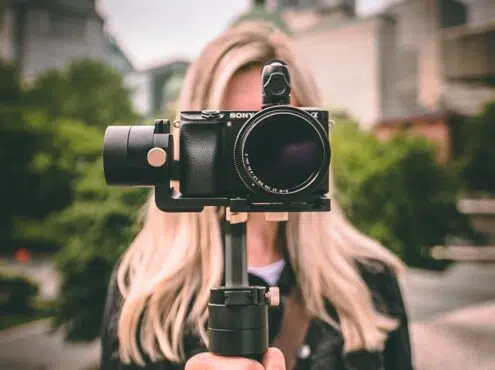 selective focus photography of woman holding camera gimbal