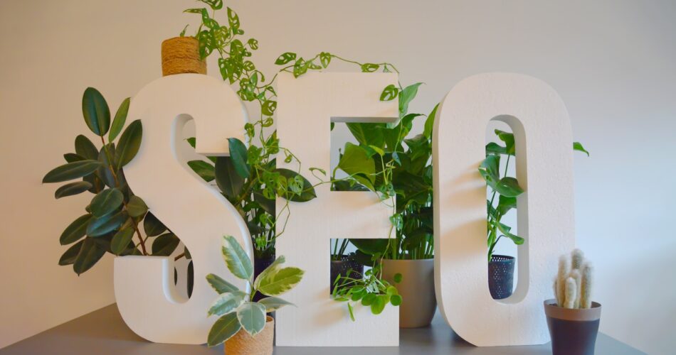 a white sign with plants and a potted plant next to it