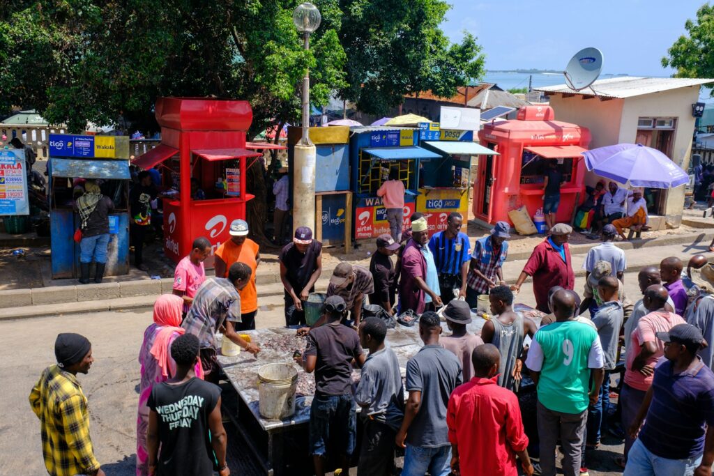 M-Pesa & Payment Gateway "Auto-Collector" 1 a crowd of people standing around a street vendor