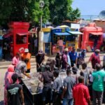 a crowd of people standing around a street vendor