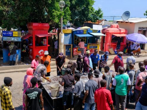 a crowd of people standing around a street vendor