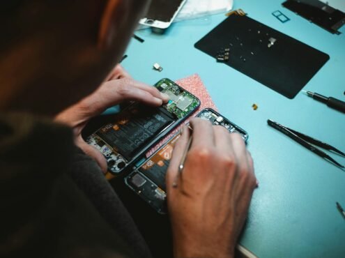 person repairing smartphones under a lighted table